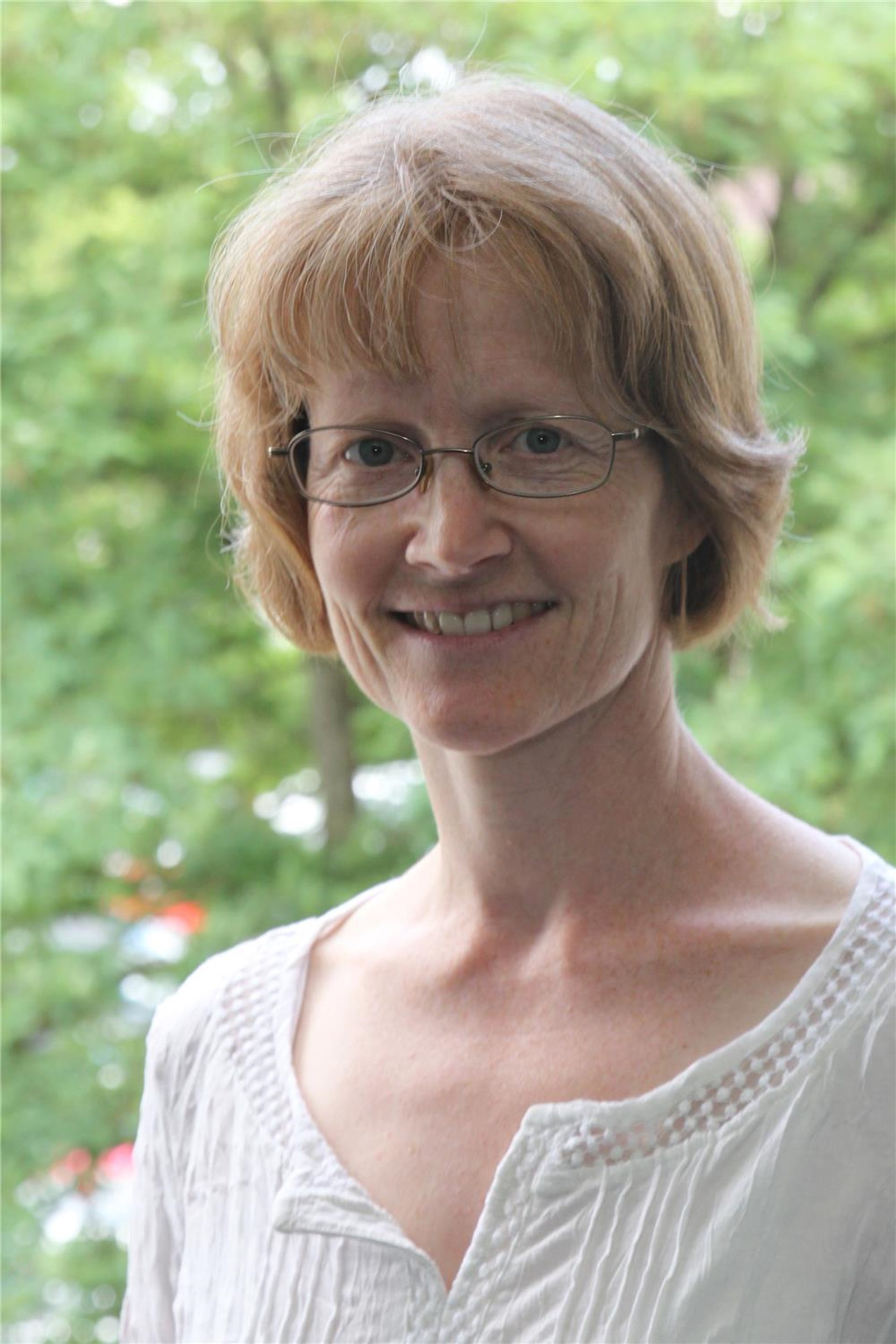 Frauengesicht vor einem begrünten Hintergrund